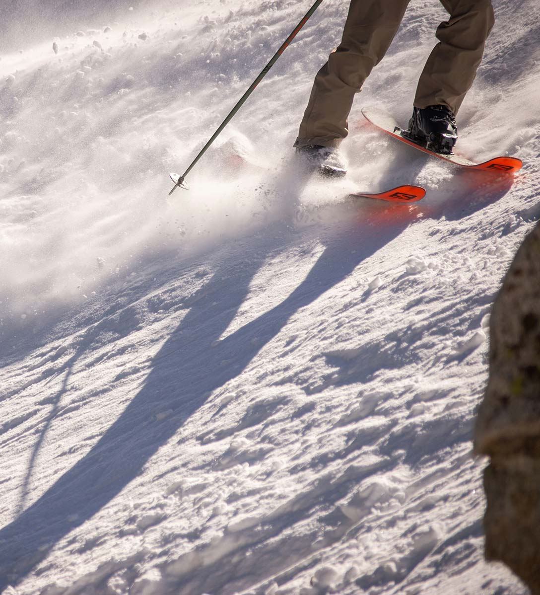 Person skiing downhill on snowy slopes.