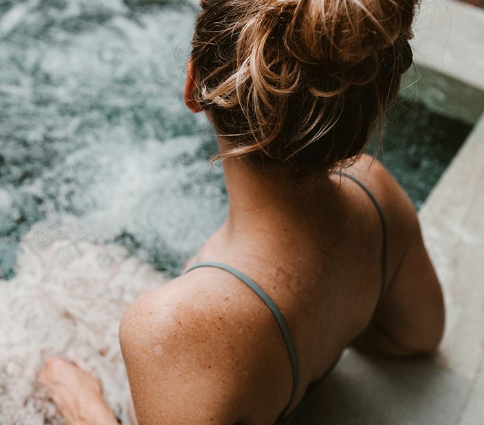 Person in bikini relaxing in hot tub.