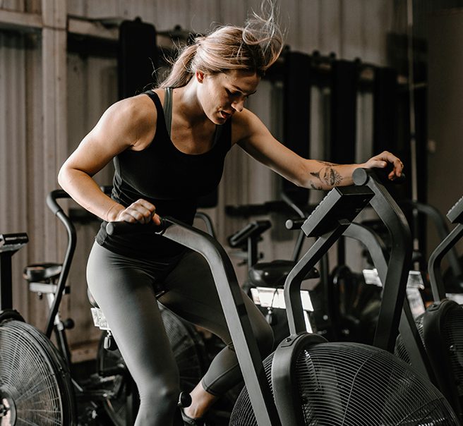 Person exercising on large stationary bike.