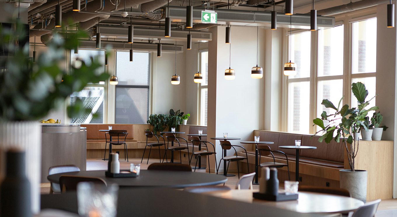 Lounge with booth seating, modern furnishings, and large bright windows.