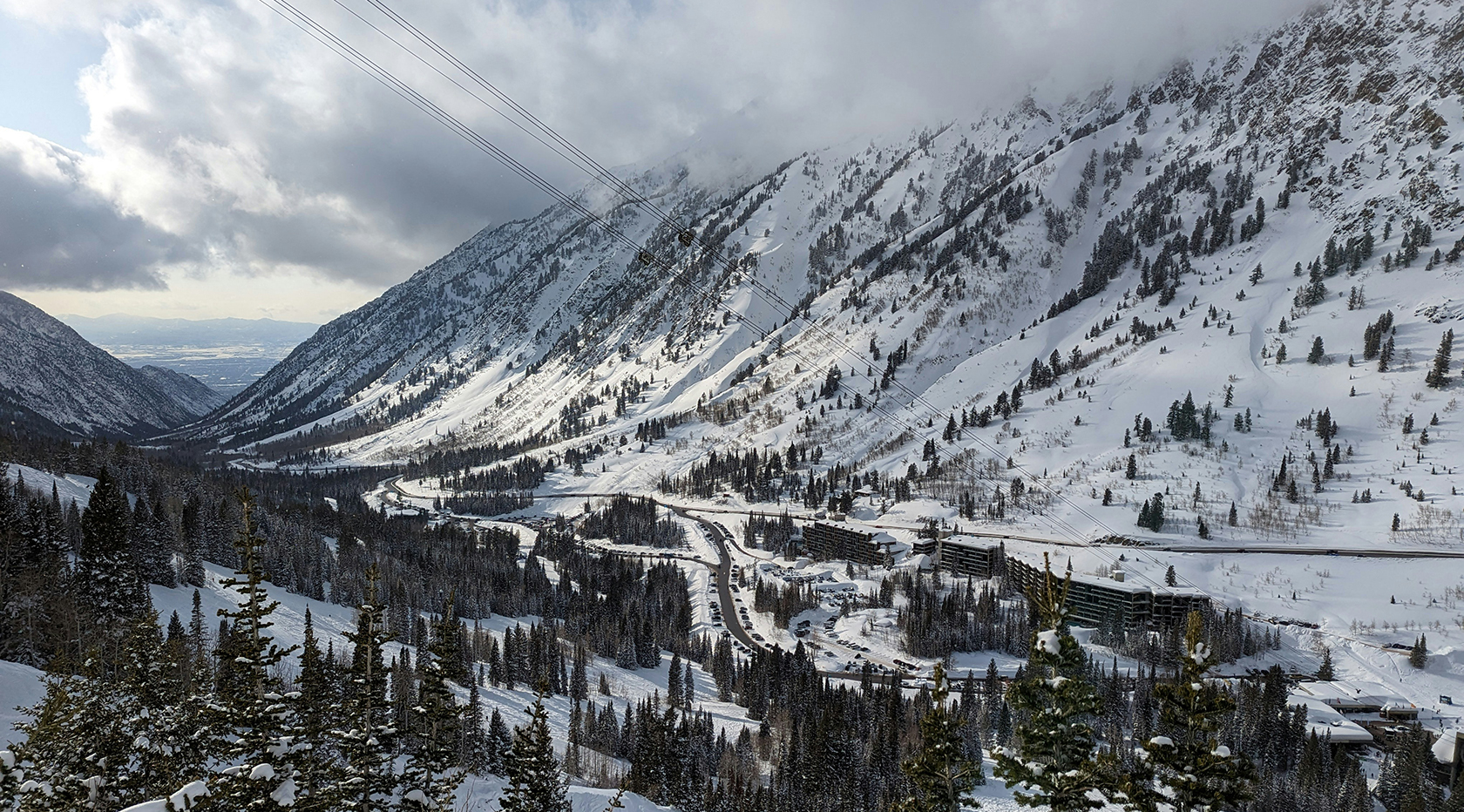 Snowy valley in winter with ski resort.