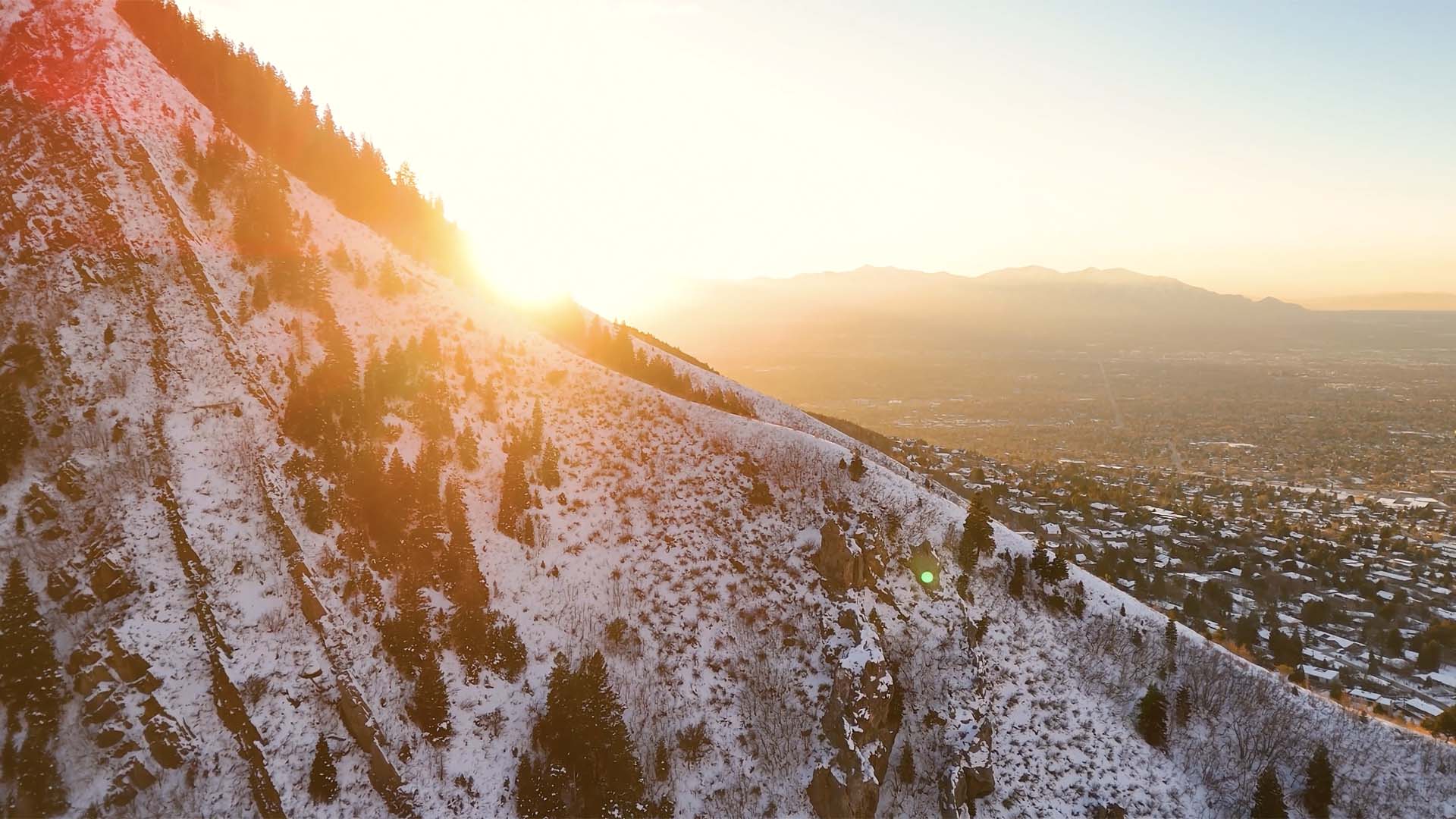 Sunrise over snowy, rocky mountains.